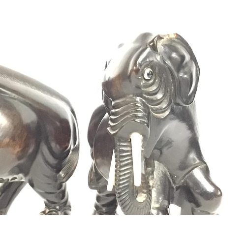 802 - A pair of ebony elephants 18cm tall approximately. Postage cat b