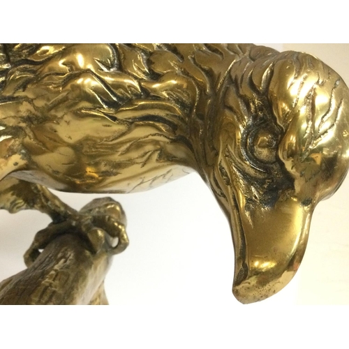 808 - A large brass Bald eagle perched on a log. Approximately 62cm tall, 70cm wide. Postage cat D