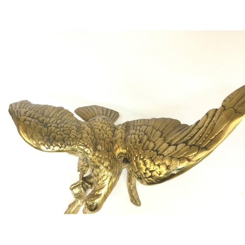 808 - A large brass Bald eagle perched on a log. Approximately 62cm tall, 70cm wide. Postage cat D