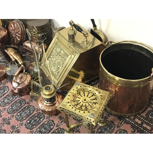 822 - A large collection of brass and copper ware including fireplace tools, decorations, an oil lamp, pho... 