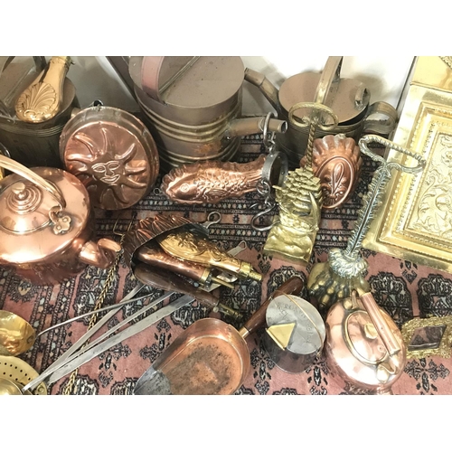 822 - A large collection of brass and copper ware including fireplace tools, decorations, an oil lamp, pho... 