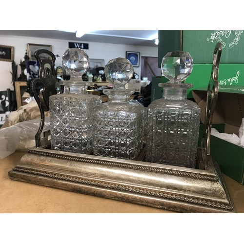 1028 - A silver plated tantalus inset with three glass decanters