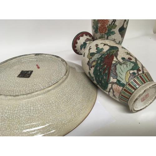 1121 - A Chinese Crackleware dish decorated with warriors and a pair of conforming vases decorated with exo... 