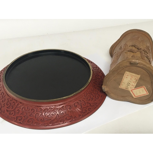 1122 - A cinnabar lacquer type dish diameter 25cm and a carved wood vessel with cover (2)