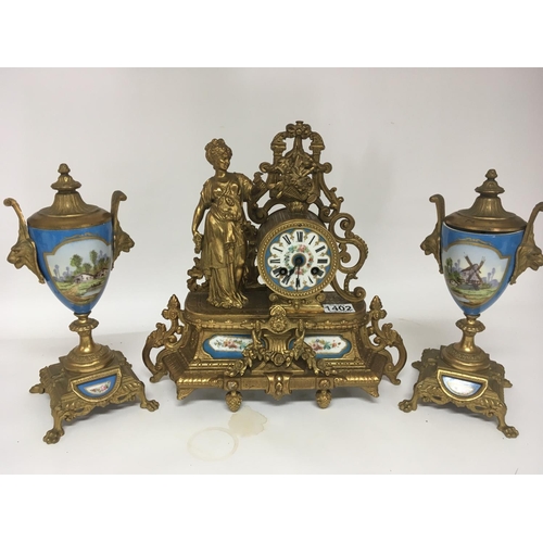 1256 - A French late 19th century gilt metal clock with porcelain panels and surmounted with a female class... 