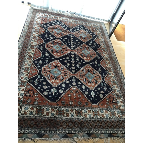 1315 - A hand knotted rug with a geometric lozenge pattern with red and blue field