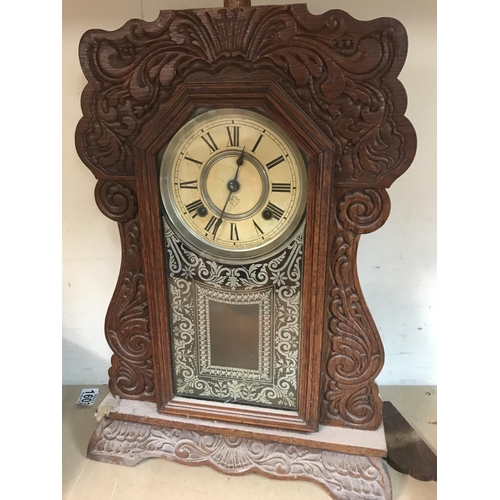 1331 - A walnut mantle clock with applied carvings the circular dial with Roman numerals. Together with two... 