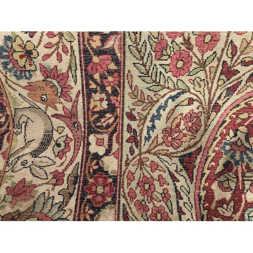 1387 - A Kirman style part silk rug depicting mythical animals on a red ground and folate border. Measuring... 