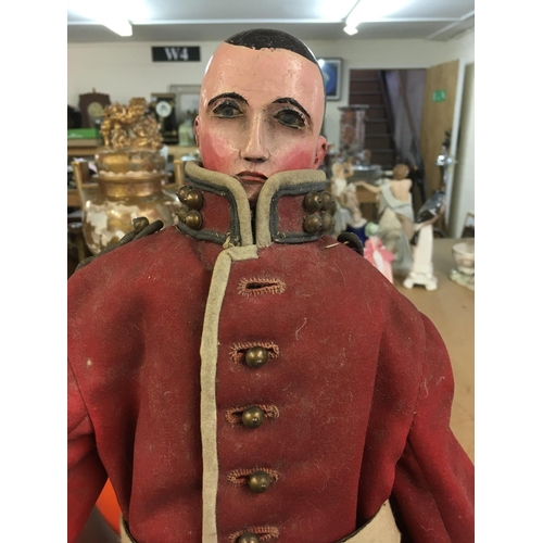 2121 - A 19 th century wooden joined doll in the form of a solider 53 cm .