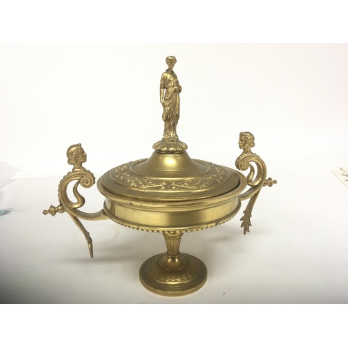 621 - A Neo Classical gilt metal urn the lid with a raised figure flanked by scroll supports height 20cm- ... 