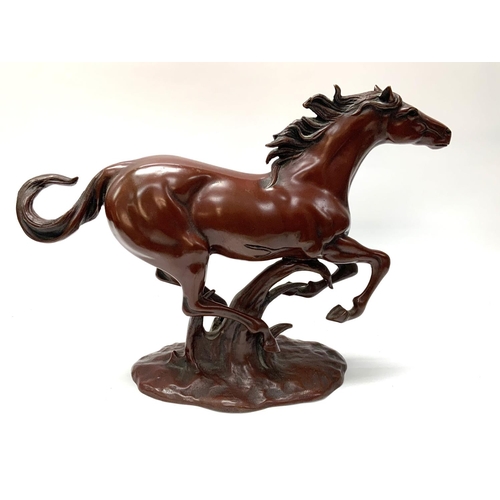 623 - A cast bronze lacquered model of a galloping horse. 27cm x 36cm.