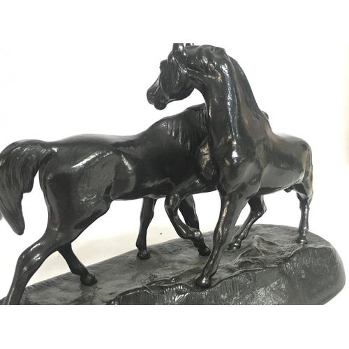 628 - A Soviet Russian black metal statue of two horses, approximately 24cm wide & 16cm tall. Postage cate... 