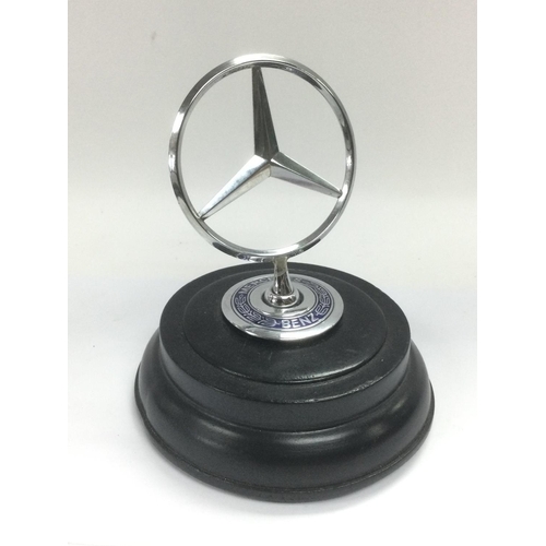 681 - A Mercedes car badge raised on an ebonised base, approx height 14cm. Shipping category B.