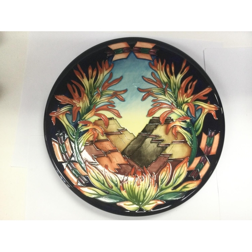 910 - A boxed Moorcroft circular wall plaque depicting stylised mountains, monogrammed to base, approx dia... 