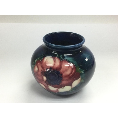 912 - A circa 1950s boxed Moorcroft vase with floral decoration on a dark blue ground, approx height 7.5cm... 