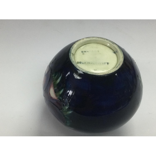 912 - A circa 1950s boxed Moorcroft vase with floral decoration on a dark blue ground, approx height 7.5cm... 