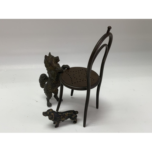 1060 - A small cast bronze dog figure leaning on a chair. 15cm together with a small cold painted bronze sp... 