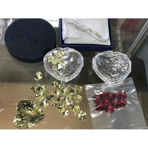 1409 - Two Swarovski heart shaped trinket boxes, together with loose hearts in yellow and red. Also a boxed... 