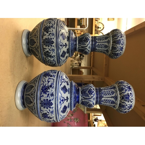 1434 - A pair of German pottery vases on blue ground. Height 33cm