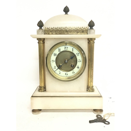 1555 - A French Onyx clock decorated with pillars, acorns and a bronzed dial. 34cm tall with key. Postage c... 