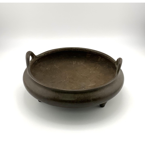 902 - A Japaneese shallow 3 footed 2 handled bronze censor. 17cm x 8cm.