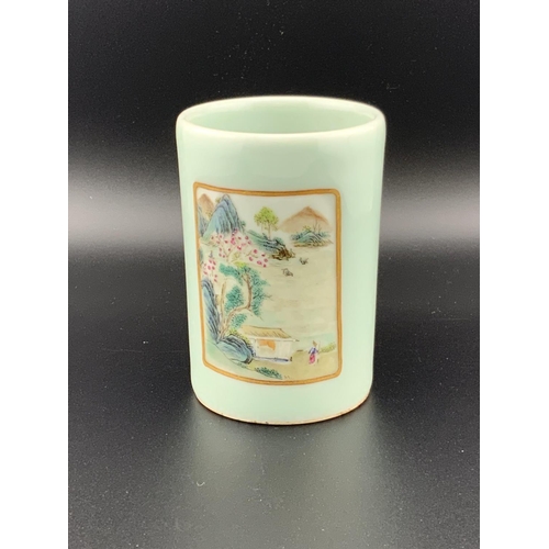 922 - A small Chinese celadon glazed brush pot with 2 hand painted landscape scenes, 8.5cm. Underglazes ma... 