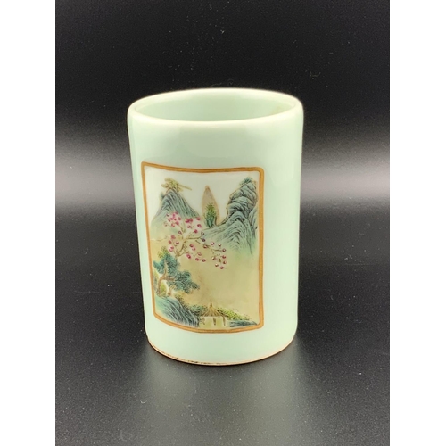 922 - A small Chinese celadon glazed brush pot with 2 hand painted landscape scenes, 8.5cm. Underglazes ma... 