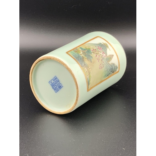 922 - A small Chinese celadon glazed brush pot with 2 hand painted landscape scenes, 8.5cm. Underglazes ma... 