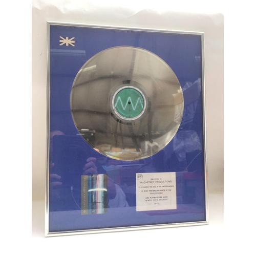 644 - A framed and glazed BPI silver disc of Wings Over America presented to McCartney Productions recogni... 