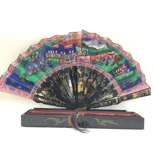 1133 - A boxed Chinese fan decorated with figures, flowers and architecture. Postage cat B