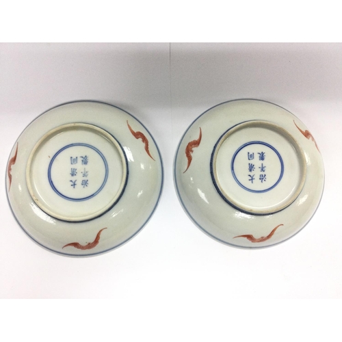 1142 - A pair of Oriental dishes decorated with cranes in a garden setting, six character marks to base, ap... 