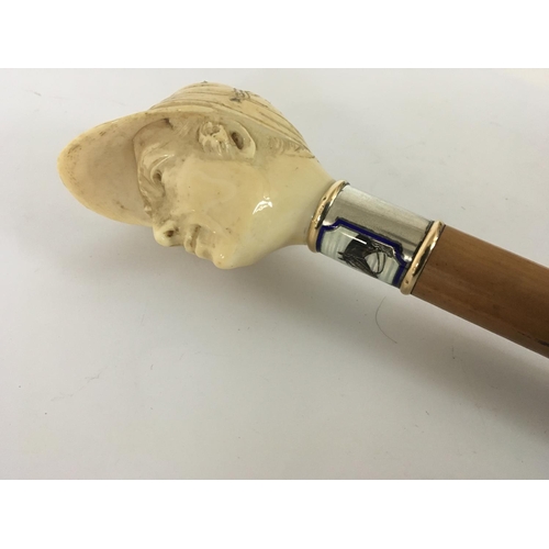 936 - A 1930s or earlier walking stick with a carved ivory top in the form of a jockeys head with a gold r... 