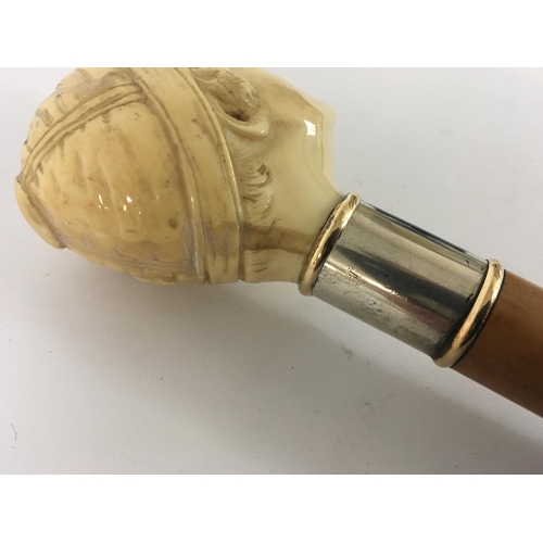 936 - A 1930s or earlier walking stick with a carved ivory top in the form of a jockeys head with a gold r... 