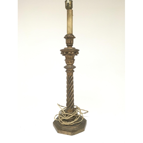 944 - A carved guilt wood candle stick with a stylised spiral twist column. Height 53cm.