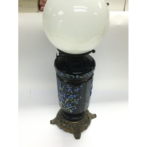 946 - A Victorian oil lamp and shade, the font and base decorated with raised floral decoration. Shipping ... 