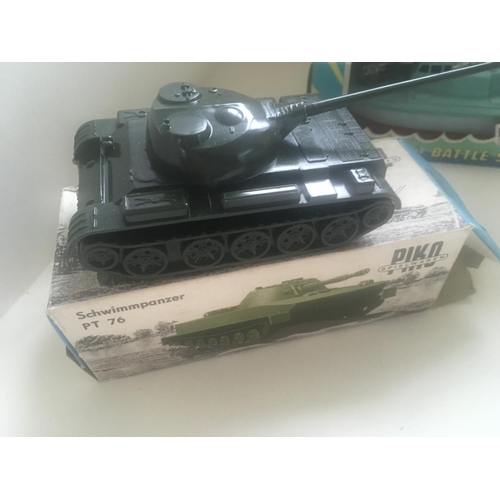 504 - Collection of four boxed toys in the original packaging. Comprising tin plate model tank with workin... 