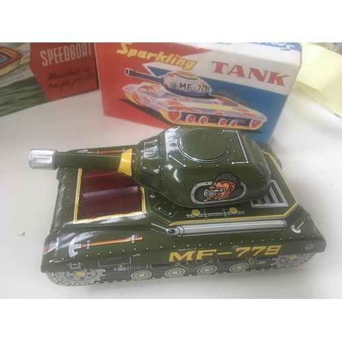 504 - Collection of four boxed toys in the original packaging. Comprising tin plate model tank with workin... 