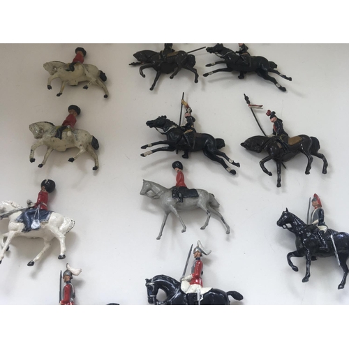 520 - A collection of 14 lead figures by Britains and others. Theme of mounted soldiers