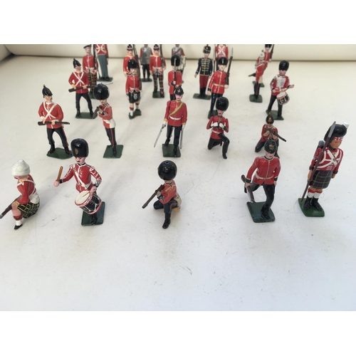 745 - A collection of 25 metal model soldiers mainly Britains. Features and assortment of stances and regi... 