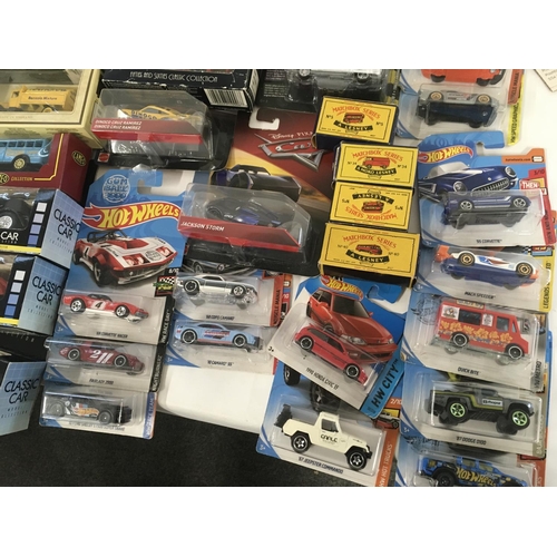 882 - A collection in excess of 60 model cars by a variety of manufacturers mostly in original packaging