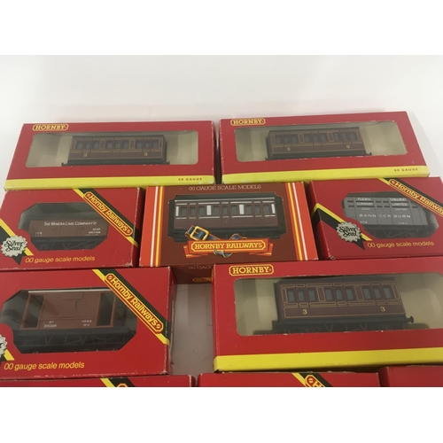 910 - A collection of 12 boxed model railway carriages and wagon. Mostly Hornby 00 gauge.