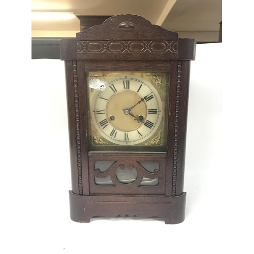 130 - Two clocks including A walnut mantel clock with a silvered dial and An oak mantle clock with key and... 