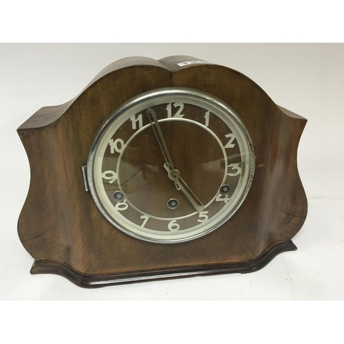 132 - An Art Deco design walnut clock. With three train movement.