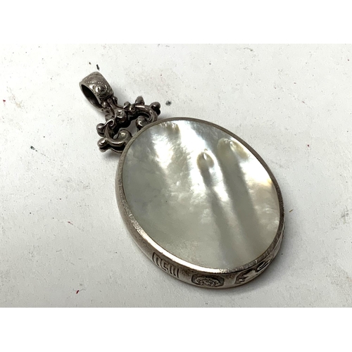 235 - A Sterling silver pendant with marks for Sheffield 1982, inset with mother of pearl and Jasper.