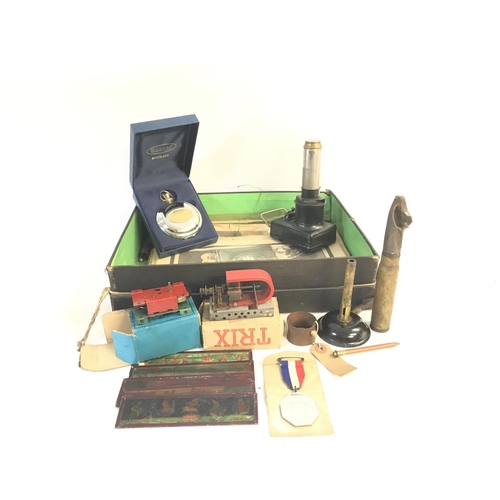 507 - A box of of items including: a Middlesex county medal, two miniature motors, a Bunsen burner, a napk... 