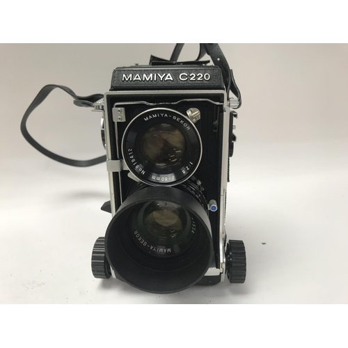 64 - A vinatge Mamiya C220 twin-lens reflex camera, with attached lenses, Working order.