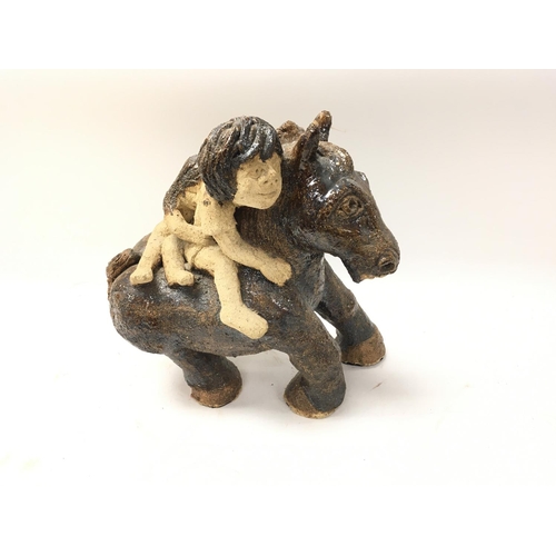 89 - A Studio pottery horse with two people riding .