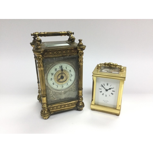 9 - An ornate brass framed carriage clock with enamel chapter ring plus a smaller carriage clock by Lion... 