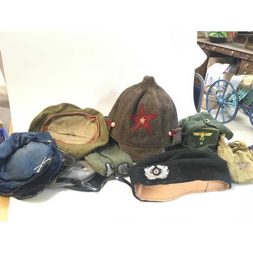 801 - A collection of retrospective military hats including SS side cap, Russian CCCP hat etc.