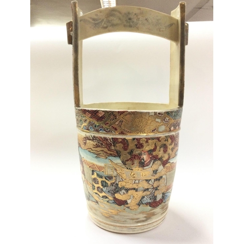 1002 - A Japanese satsuma bucket vase, decorated with figures. 31.5cm tall approximately. Postage category ... 